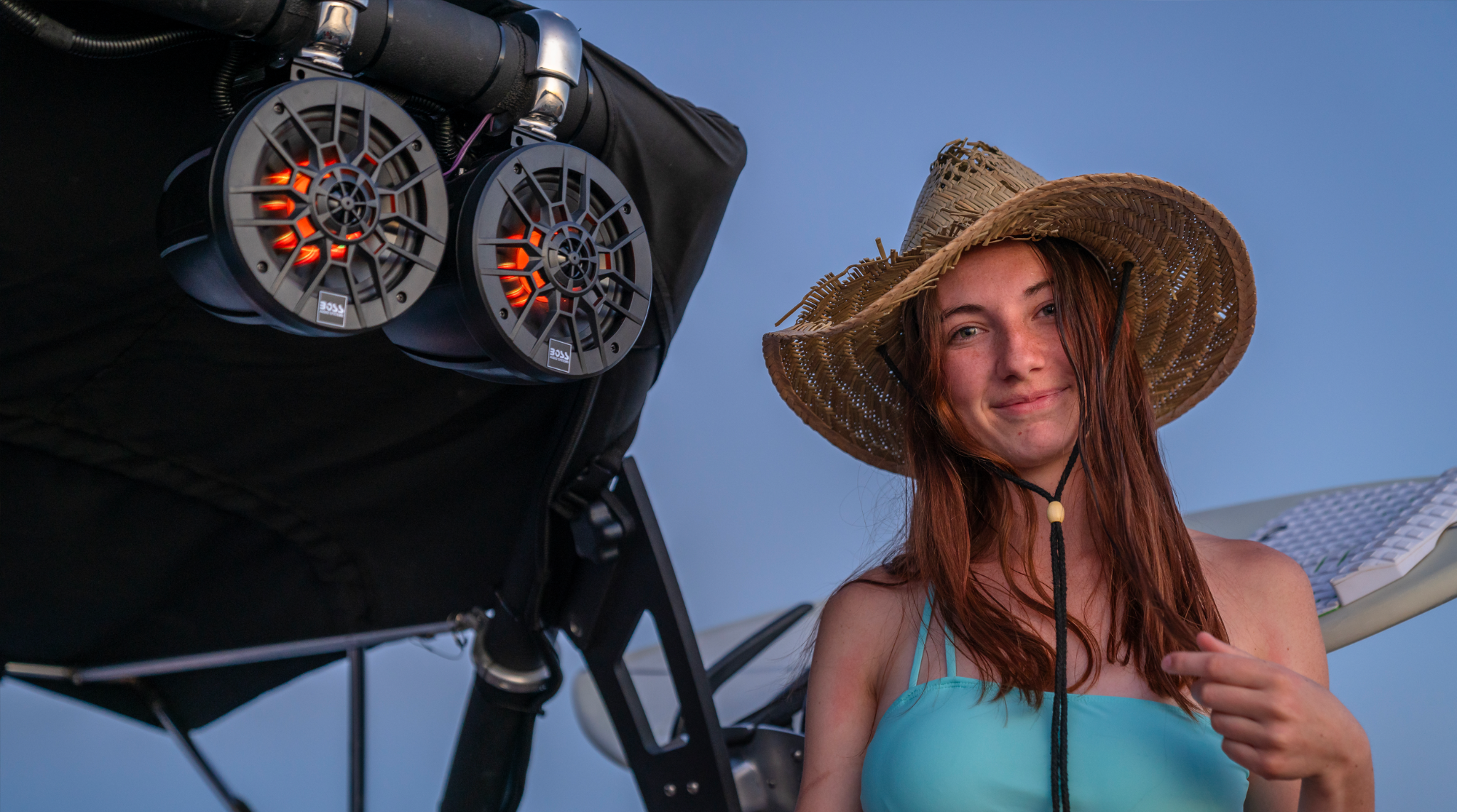 Woman beside a boat fitted with BOSS marine speakers